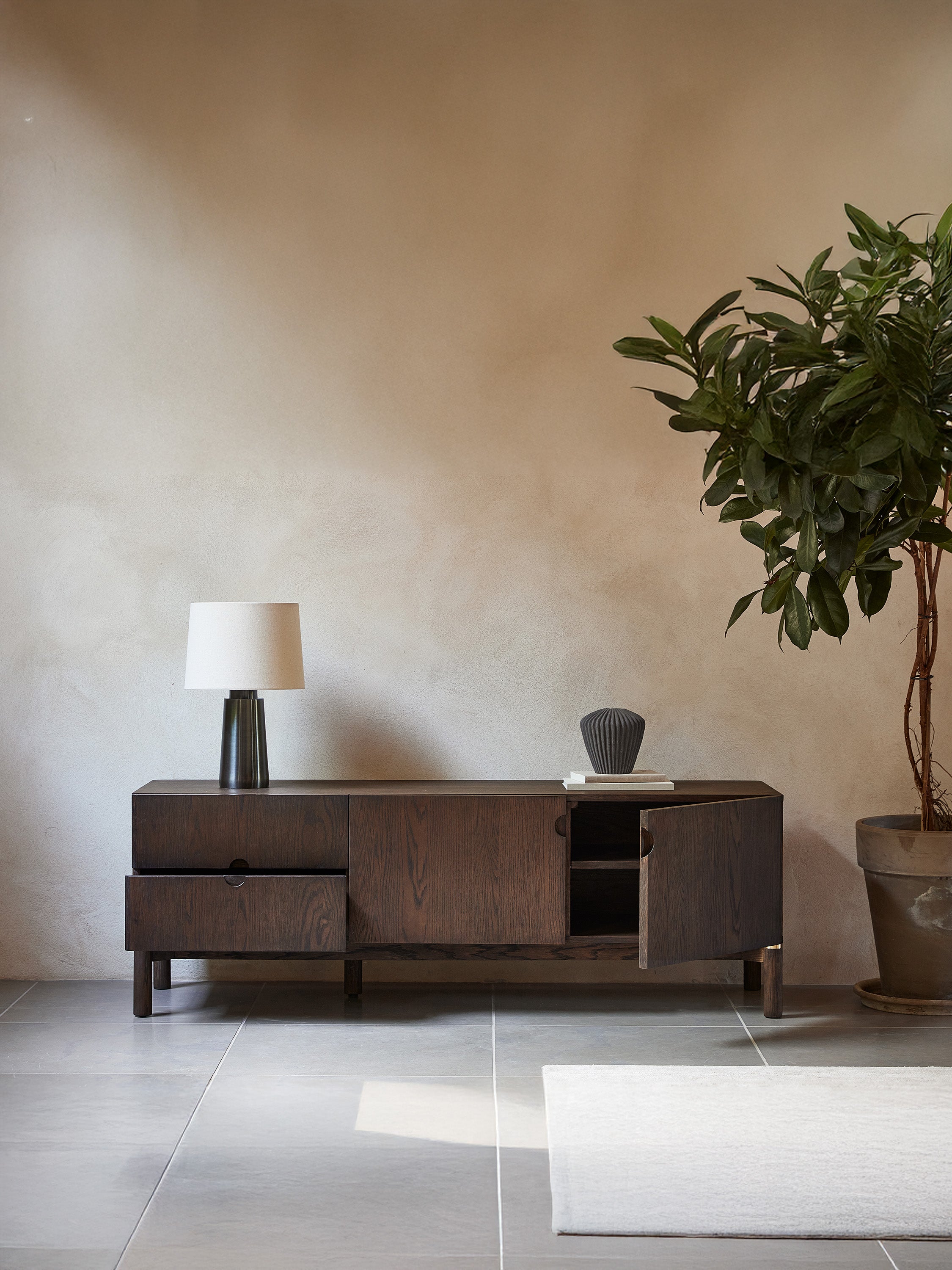 Mueble TV Arun en madera maciza oscura y acabados de latón 160 x 55 cm