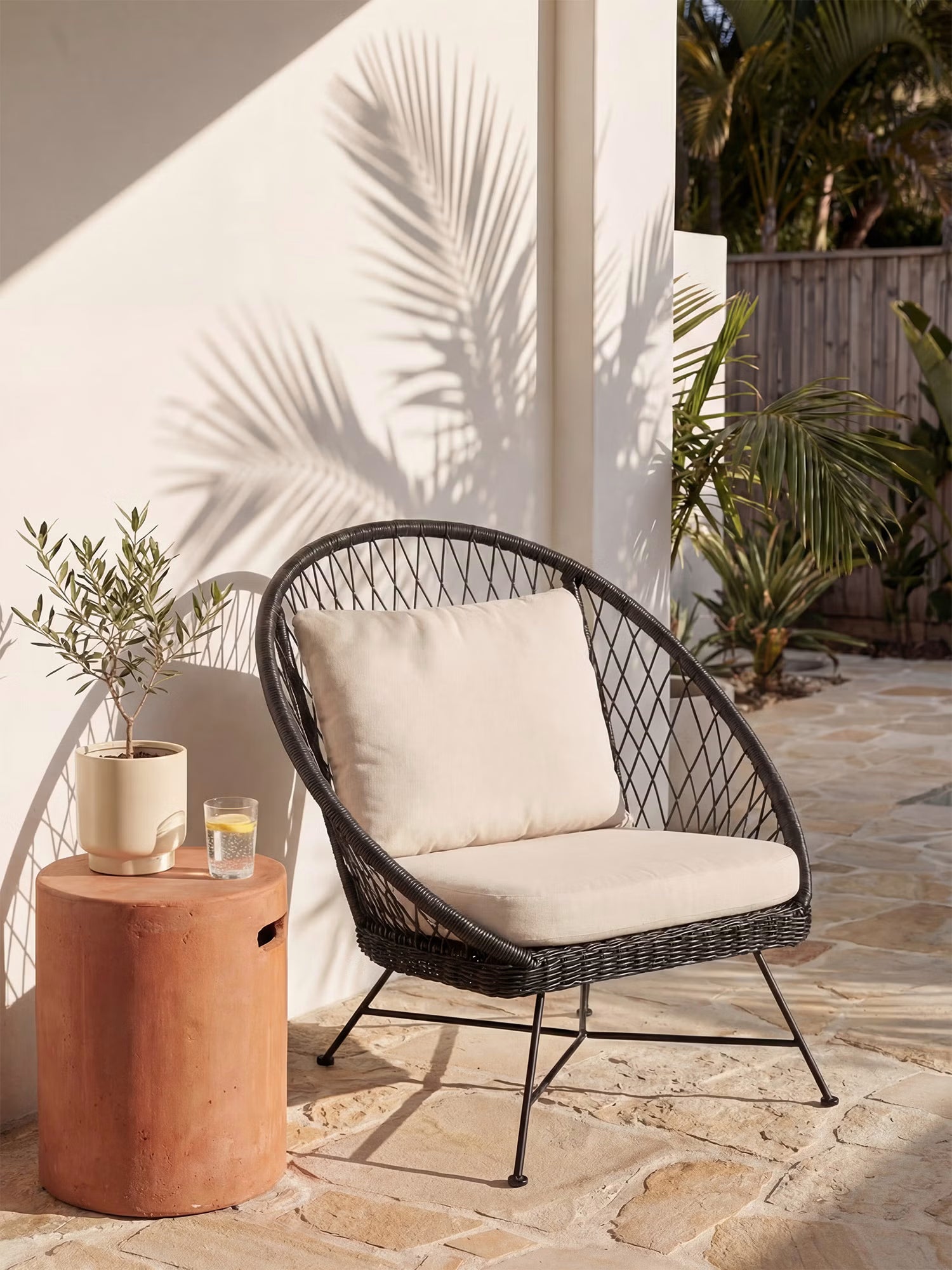 Nyra Sillón de exterior en mimbre negro y aluminio con cojines color arena